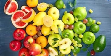 Fresh raspberries, grapefruit halves and avocado arranged as diabetes friendly fruits.