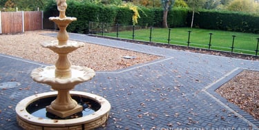 Charcoal standard block paving large patio and glass wall.