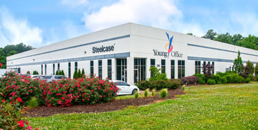 Modern white commercial office building for Young Office and Steelcase with red roses in the foreground.