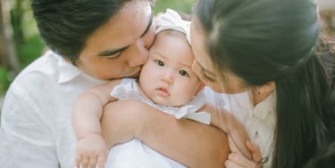 Parents kissing baby during intimate family photography session at Sofitel Nusa Dua Bali
