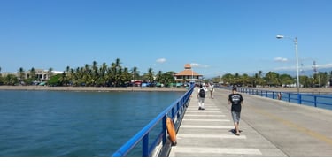 Vista do navio ancorado em Puntarenas, Costa Rica, com pier e cidade ao fundo