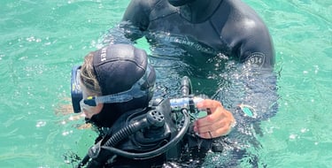 a man and a woman in scuba gear in the water