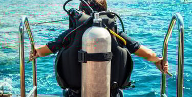 a man in a diving suit is standing on a boat