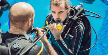 a man in a scuba suit is holding a scuba suit