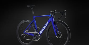 Blue Giant Propel Advanced SL road bike with carbon wheels and electronic shifting on a black background.
