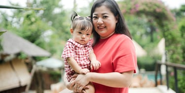 mother holding child in a natural family photography moment at Movenpick Jimbaran Bali resort