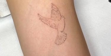 extra feines fineline Tattoo eines Vogels, das Melina in Potsdam gestochen hat.