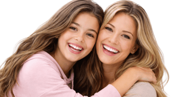 A smiling mother and daughter with healthy white teeth and long blonde hair hugging on a black background.