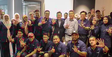 a group of people standing around a man in a blue shirt