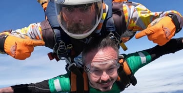 A white male doing a skydive with their disability showing