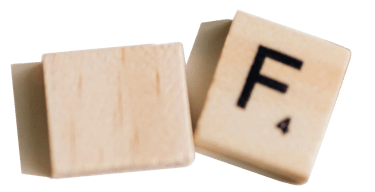 Two wooden Scrabble tiles, one blank and the other with the letter "F" and a score of 4.