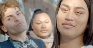 Three people gazing or smiling into the camera.