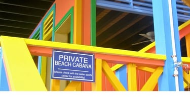 Placas em cabanas de luxo em Half Moon Cay indicando necessidade de reserva.