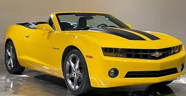a yellow convertible car with a black and white background