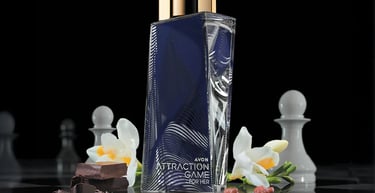 Avon Attraction Game for Her perfume bottle with amber and woody notes on a chessboard with white flowers.