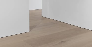 Close-up of baseboard trim installed along hardwood flooring.