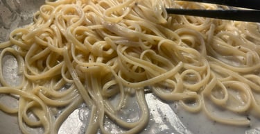 Authentic Italian cacio e pepe pasta being tossed in a creamy pecorino cheese sauce.