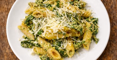 Penne pasta with creamy spinach and ricotta sauce topped with shredded parmesan cheese.