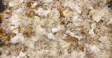 Homemade baked pasta dish topped with layers of shredded mozzarella and ricotta cheese in a glass pan.