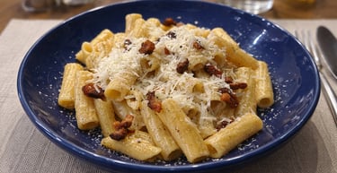Rigatoni alla Gricia pasta with crispy guanciale and pecorino cheese in a blue bowl.