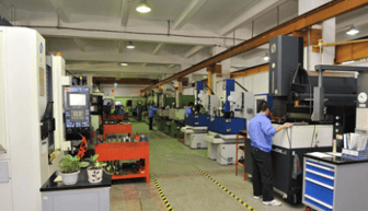 Industrial mould precision machining workshop with workers operating CNC milling or lathe equipment.