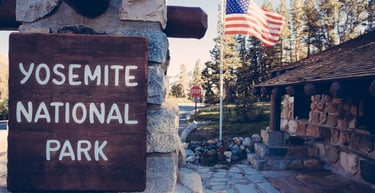 Entrada principal do Parque Nacional de Yosemite com paisagem montanhosa ao fundo.