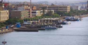 foto do navio navegando pelo canal de suez com vista para vilarejo