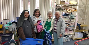 Rose Garden Volunteers sorting children's clothing. 