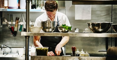 a man in a kitchen preparing food in a kitchen