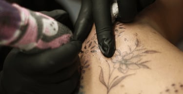 gros plans sur les mains d'Eva Ink vlr qui tatoue des pattern artistique dans le dos de sa cliente