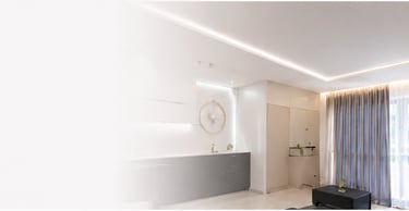 Modern living room with recessed ceiling lighting, sleek grey cabinets, and elegant floor-to-ceiling curtains.