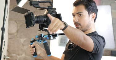 Director de cine dirigiendo la producción de un video corporativo profesional en set de filmación