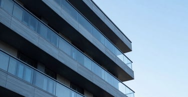 Abstract architectural detail of a modern building with clean lines and steel blue panels against a clear sky.