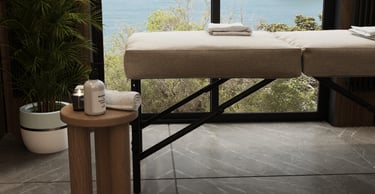 a massage table with towels and side table with candle