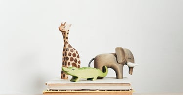 Toy wooden animals on stacked books