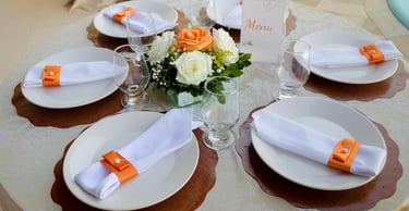 "Decoração de mesa com guardanapos e arranjo de flores"