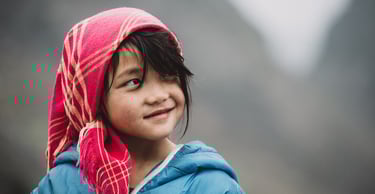 a young girl wearing a pink scarf and a pink scarf