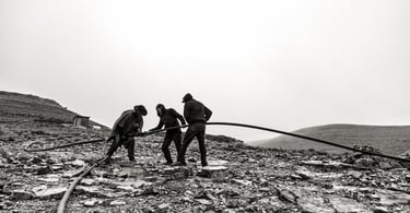 a group of men working on a rocky mountain