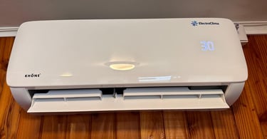 a white air conditioner sitting on a wooden floor