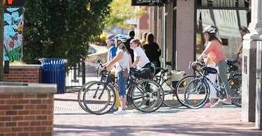 4 women on bikes stopped at a stop light