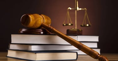 A gavel lying over a deck of legal books