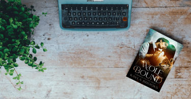 flatlay of Wolf Bound by Kayla Brooks sitting next to a typewriter and plant
