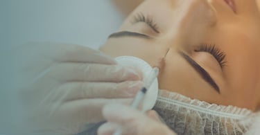 Mujer a la que le están inyectando botox en la frente