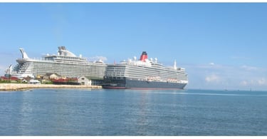 Navios de cruzeiro Oasis of the Seas e Queen Elizabeth ancorados em Falmouth, Jamaica, mostrando o porto e a costa tropical