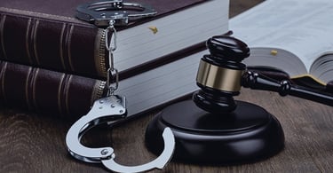 Sudski čekić, lisice i knjiga pravnih propisa , simbol kaznenog i prekršajnog prava