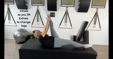 a woman executing a scissor in Pilates Mat exercise