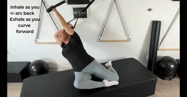 a woman hanging laterally in spine extension using a suspension trainer