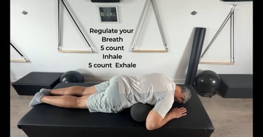a man laying on a bolster to work his lateral intercostal breathwork