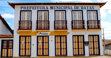 Prefeitura Municipal de Datas, em Minas Gerais, com fachada branca e detalhes em amarelo e azul