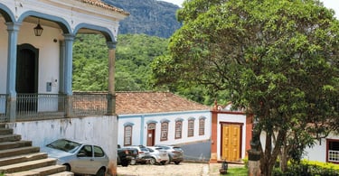 Casario colonial de Tiradentes com varandas históricas, igreja ao fundo e Serra de São José cercando